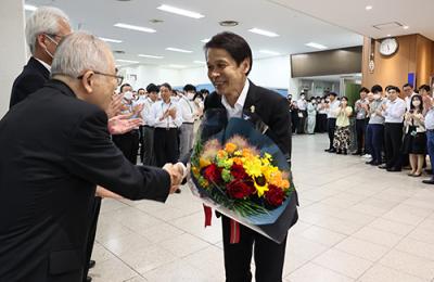 花束を手に笑顔の梅本副市長