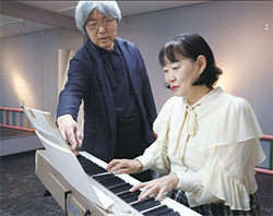 作曲を指導している河野敦朗さんと受講生の女性