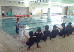 水泳の授業を受けている小学生たち