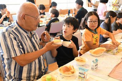 給食を食べる農業者と児童